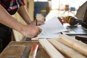 Hands of person doing diy project at home. Man measuring wood to doing cabinet craftworks as a hobby.