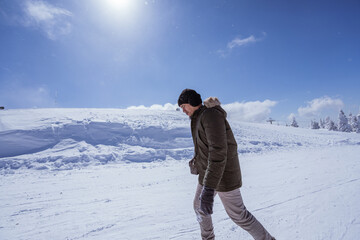 portrait of a man walking on top of the snowy mountain in bursa turkey