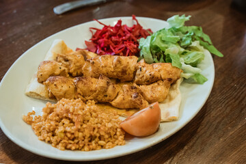 close up chicken grilled served with rice and pita bread and fresh vegetables