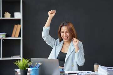Cheerful and beautiful Asian businesswoman is excited and delighted that she has successfully accomplished her goals beautifully.
