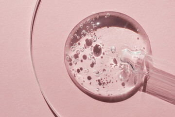 Pipette with sample of gels cosmetic product in petri dish on pink background, hard shadows - obrazy, fototapety, plakaty