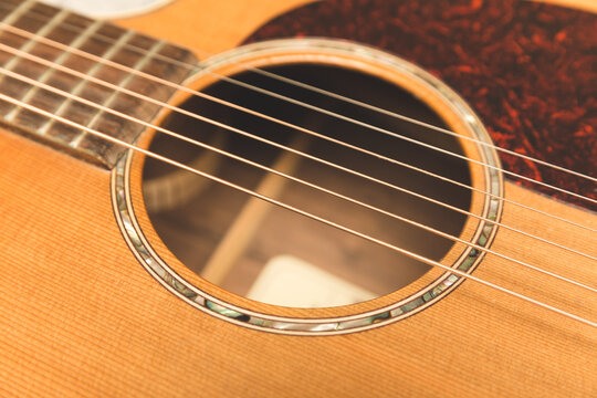 Steel strings on an ornate acoustic guitar