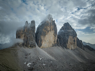 Cloudy day after the storm in the Dolomites mountains with mountain peaks looking up from the fog, mist, and clouds. 