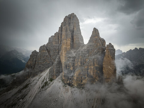 Cloudy day after the storm in the Dolomites mountains with mountain peaks looking up from the fog, mist, and clouds. 