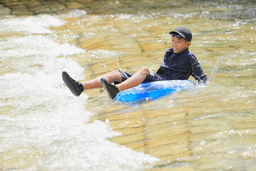 川で浮き輪で遊ぶ男子中学生 (12歳)