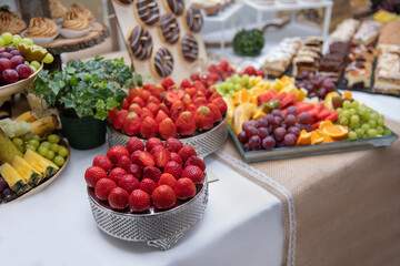 truskawki i inne owoce na przyjęciu na słodkim stole jako deser - obrazy, fototapety, plakaty