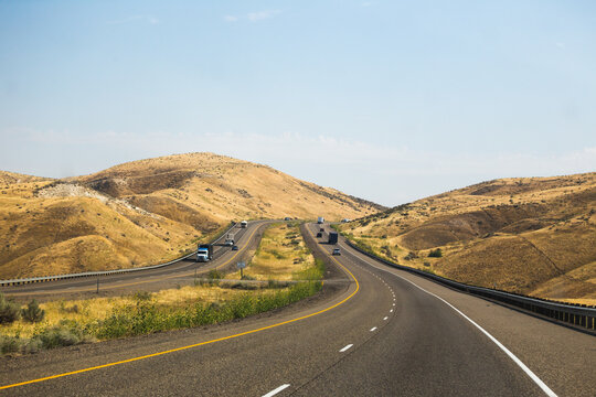 Winding highway in desert landscape, golden hills, Oregon - Idaho border