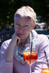 Portrait of an attractive mature woman with a glass of bright color drink