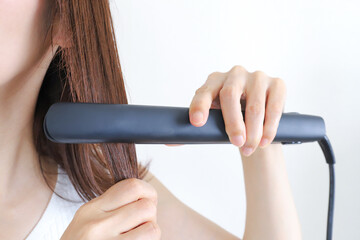 ストレートアイロンを使う女性