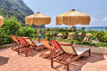 Rustic stairs and pathways amongst the colourful beach chairs and umbrellas in the hot springs on the island of Ischia in Italy
