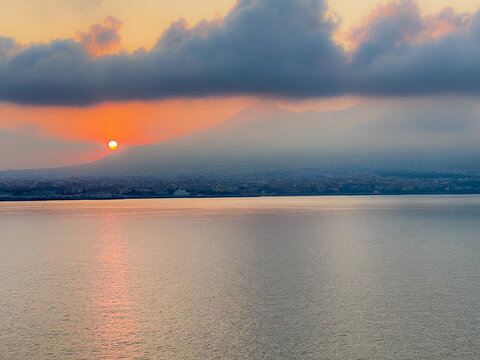 The sun rising over Mount Vesuvius viewed off the coast of Naples in Italy

