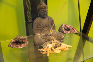 Buddhist figure with crystals, rocks, and incense