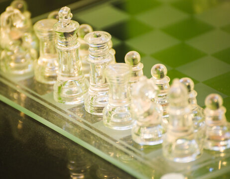 Glass chess pieces on glass chess board