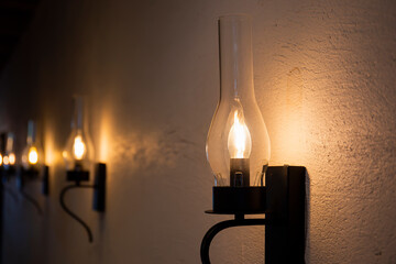 Antique electronic lamps attached to a cement wall.