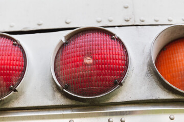 Red and amber tail lights (brake and blinker lights) on an old tour bus