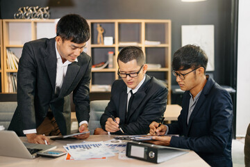 Fototapeta premium Group of young business people discussing business plan at modern startup in creative business discussing work modern office building.