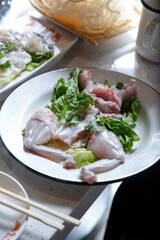 A view of raw frog meat on a plate, part of a hot pot meal.