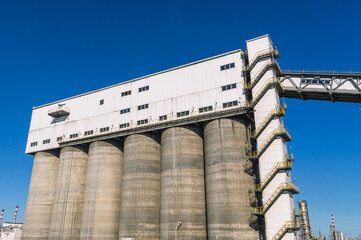 Conveyor gallery at the oil refinery. Installation of coke shipment at a petrochemical plant. Silo shipment unit. Production of deep oil refining. Technological buildings at the factory.