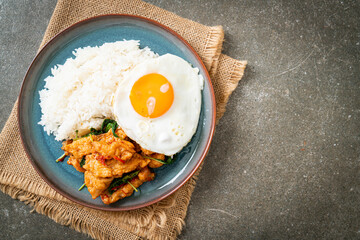 stir-fried fried fish with basil and fried egg topped on rice