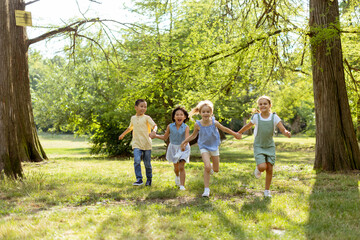 Fototapeta premium Group of asian and caucasian kids having fun in the park