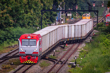 Diesel locomotive towing a gray container.