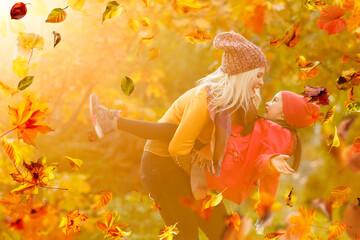 happy family: mother and child little daughter play cuddling on autumn walk in nature outdoors