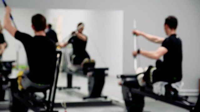 Men train in the gym on the ergometer simulator for kayaking