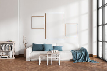 Bright living room interior with three empty white posters