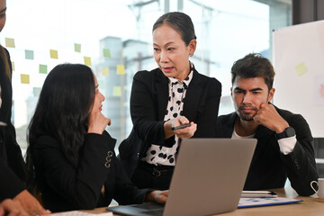 Senior old aged businesswoman sharing or discussing an ideas with business team, Mature business coach executive talking to colleague.