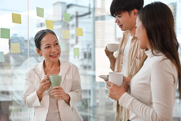 Multi-aged workers laughing have fun with coffee enjoy conversation joking take break during working day.