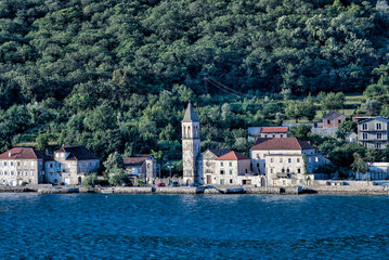 Fototapeta na wymiar Kotor, Montenegro - July 18, 2022: Shoreline buildings and piers outside of Kotor, Montenegro 