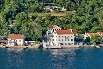 Kotor, Montenegro - July 18, 2022: Shoreline buildings and piers outside of Kotor, Montenegro
