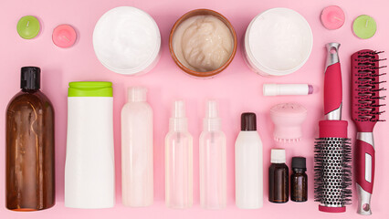 Beauty concept pattern with cosmetics bottles and products on pastel pink background. Flat lay
