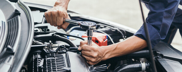 Automobile mechanic repairman hands repairing a car engine automotive workshop with a wrench, car...