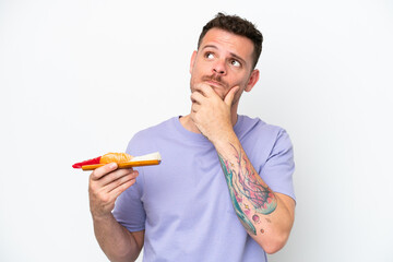 Young caucasian man holding sashimi isolated on white background having doubts