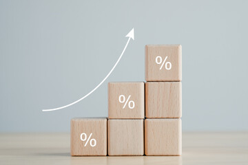 Interest rate finance and mortgage rates concept. Wooden blocks with percentage sign and rise of...