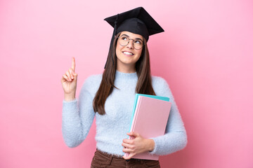 Young student Brazilian woman wearing graduated hat isolated on pink background pointing up a great...