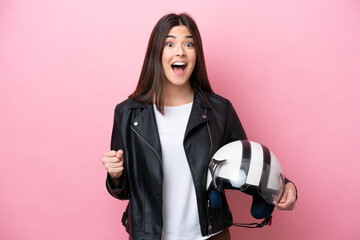 Young Brazilian woman with a motorcycle helmet isolated on pink background celebrating a victory in winner position