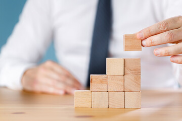 Businessman arranging wood block stacking. Business concept for growth success process