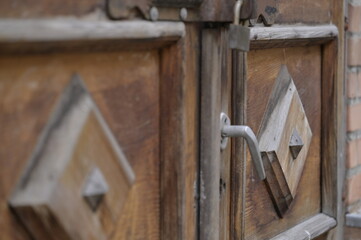 An old house built of orange bricks and its old doors and windows with a lockable padlock and handle