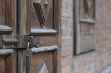An old house built of orange bricks and its old doors and windows with a lockable padlock and handle