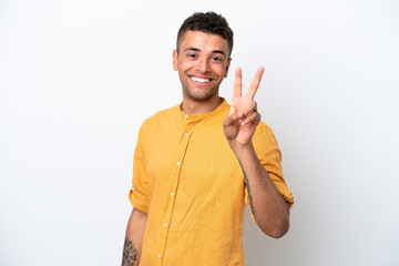 Young caucasian Brazilian man isolated on white background smiling and showing victory sign