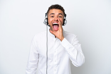 Telemarketer Brazilian man working with a headset isolated on white background shouting with mouth wide open