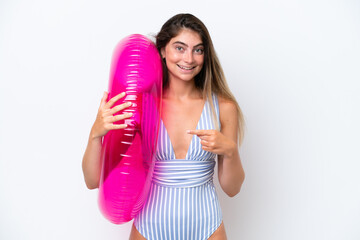 Young woman in swimsuit holding an air mattress donut isolated on white background with surprise facial expression