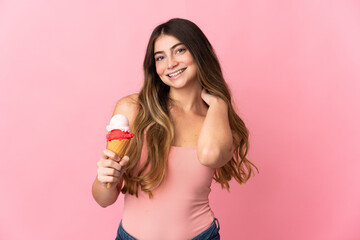 Young caucasian woman with a cornet ice cream isolated on pink background laughing