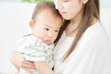 リビングで母親に抱っこされる赤ちゃん