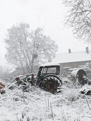 Fototapeta na wymiar snow covered old abandoned tractor