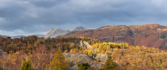 Majestic landscape image of stunning Autumn sunset light across Langdale Pikes looking from Holme Fell in Lake District