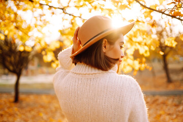 Stylish woman enjoying autumn weather in the park. Fashion, style concept.