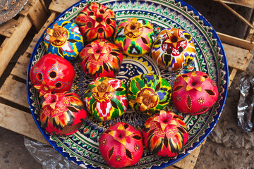 a plate with clay pomegranates in the tourist market of tashkent. artificial pomegranate symbol of...